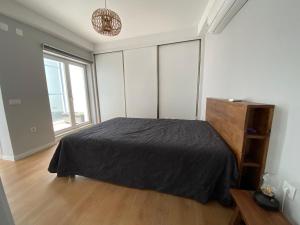 1 dormitorio con 1 cama con edredón negro en Casa da Serpa Pinto, en Évora