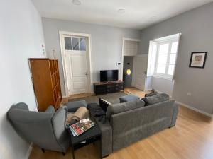 uma sala de estar com dois sofás e uma televisão em Casa da Serpa Pinto em Évora