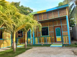 a colorful house with a palm tree in front of it at Hope Homes in Panglao