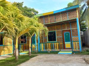 a colorful house with a palm tree in front of it at Hope Homes in Panglao Island