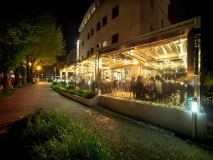 オデルツォにあるPostumia Hotel Designの夜間外に立つ集団