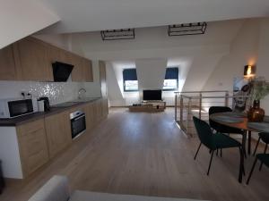 a large kitchen and living room with a table and chairs at Charming duplex on the canal Brussels in Brussels