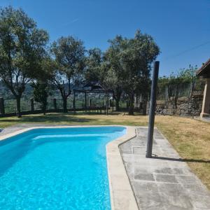 a blue swimming pool with a pole in a yard at Casa 2 habitaciones con piscina y cenador al aire libre in Pontevedra