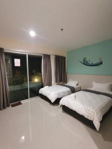 Un dormitorio con dos camas y una ventana. en Rustic one bedroom unit for 4pax by Jomy Management, en Lumut