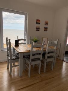 a dining room table and chairs with a view of the ocean at Eastcliffe Penthouse, 2 beds & bathrooms with parking in Cleethorpes
