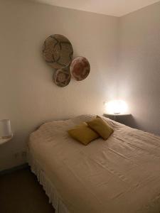 a bedroom with a bed and two hats on the wall at Rêves Salés in Mimizan