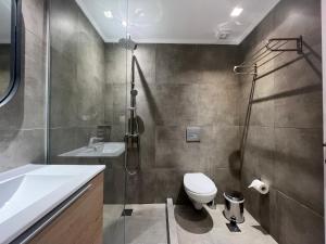 a bathroom with a toilet and a shower and a sink at Elephant Suites in Thessaloniki