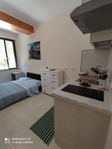 a kitchen with a sink and a bed in a room at F&L A TAORMINA in Taormina