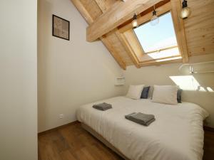 a bedroom with a large white bed with a window at Au Vert ! in Le Vert