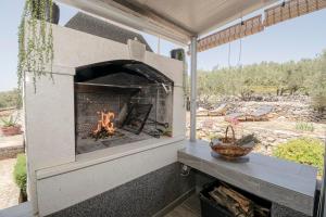 a fireplace in a patio with a table and a bench at Holiday House Roza in Vela Luka