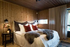 1 dormitorio con 1 cama grande con almohadas en Cozy modern holiday villa with electric car charging, sauna and fireplace en Øyer