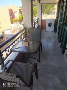 een patio met een tafel en stoelen en een wasmachine bij Villa Magdalini in Lákones