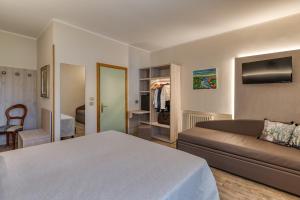 a bedroom with a bed and a couch in a room at Hotel Aurora in Cimego