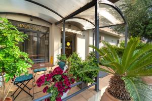 a patio with flowers and plants in front of a building at Zen Hotel in Athens