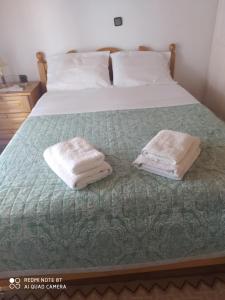 een slaapkamer met een bed met twee handdoeken erop bij Villa Magdalini in Lákones