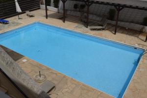 a large blue swimming pool in a yard at Eden Heights Sea View Apartment 203 - By IMH Travel & Tours in Paphos City
