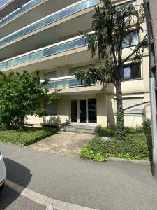 budynek z drzewem przed nim w obiekcie KASA VOYTIER Parking privé & Wifi - Balcon & Ascenseur w mieście Saint Etienne +4 zdjęcia