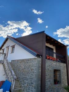 Casa con balcón con sillas rojas. en Villa Shuaipaj, en Gjirokastra