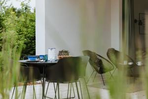 a table and chairs in a room with a window at Leśny Apartament - Shuuumi Las in Chmielno