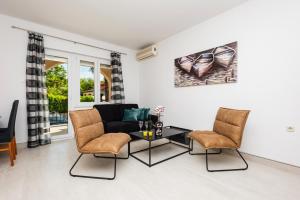een woonkamer met een bank en stoelen bij Apartments Dino in Malinska