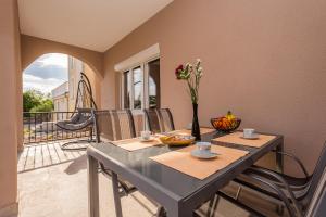 een eetkamer met een tafel en een balkon bij Apartments Dino in Malinska