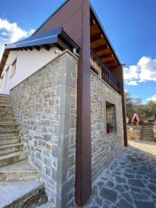 - un bâtiment avec un mur et des escaliers en briques dans l'établissement Villa Shuaipaj, à Gjirokastër
