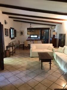 a large living room with white couches and a table at villino indipendente I Tigli in Campagnano di Roma