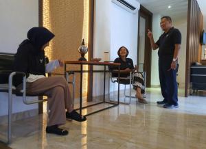 un homme et une femme assis à une table dans une pièce dans l'établissement SENAYAN SUITES, à Jakarta