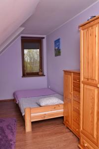 a bedroom with a bed and a dresser and a window at B10 Dom LUX z Alpakami & Basen SPA in Ełk