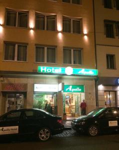 dos coches estacionados frente a un hotel por la noche en Apollo, en Frankfurt