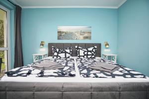 1 dormitorio con 1 cama grande y pared azul en F-1010 Strandhaus Mönchgut Bed&Breakfast DZ 24 Garten, strandnah, inkl Frühstück, en Lobbe