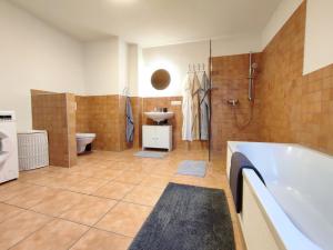 uma casa de banho com uma banheira, um WC e um lavatório. em Haus Mediterran - Gemütliches Ferienhaus 130 m² für max. 7 Personen mit Balkon und Garten am Bodensee em Radolfzell am Bodensee