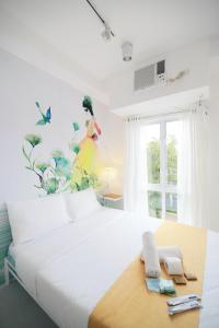 een slaapkamer met een groot wit bed en een raam bij La Bella Boutique Hotel in Tagaytay