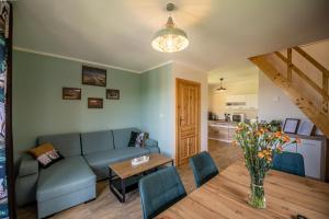 a living room with a couch and a table at Centrum Spokoju - Domki w Karkonoszach in Podgórzyn