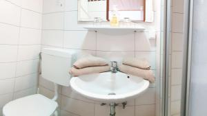 un bagno bianco con lavandino e WC di Gasthof Strobl Waldfrieden Garni a Strass im Attergau