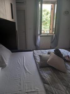 een groot wit bed met 2 kussens en een raam bij LA CASA DI CHICCO E GINNY in Verona