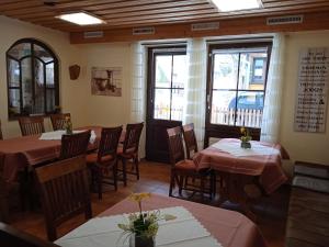 un comedor con mesas, sillas y ventanas en Pension Drei Elstern en Schierke