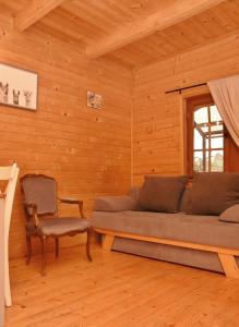 sala de estar con sofá y silla en Gospodarstwo Agroturystyczne & SPA z Alpakami, en Ełk