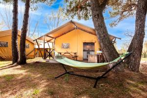 a hammock in front of a tent at Glamping and Mobile Homes Lavanda - Holiday Centre Bi VIllage in Fažana