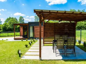 - un pavillon avec une table et des chaises dans un jardin dans l'établissement Osada Blisko Natury, à Gniezno