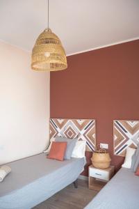 a bedroom with two beds and a hanging lamp at Apartamento AGUADULCE in Sanlúcar de Barrameda