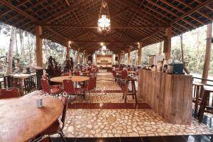 a restaurant with wooden tables and chairs and a bar at Kampoeng Semar Borobudur in Magelang