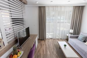 a living room with a couch and a television at Azul Beach Resort Montenegro by Karisma - All Inclusive in Ulcinj