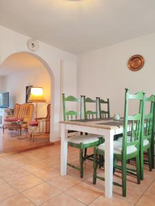 a dining room with a table and green chairs at Haus Mediterran - Gemütliches Ferienhaus 130 m² für max. 7 Personen mit Balkon und Garten am Bodensee in Radolfzell am Bodensee