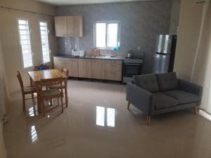 a living room with a couch and a table and a kitchen at The View Apartment in Willemstad