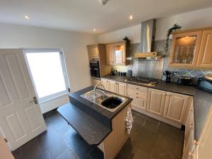 a kitchen with a sink and a counter top at Eastcliffe Penthouse, 2 beds & bathrooms with parking in Cleethorpes