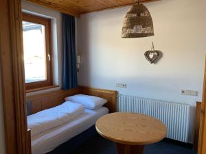 a small room with two beds and a table at Panoramaalm - Ski in - Ski out in Bad Kleinkirchheim