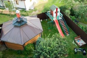 - une vue sur une petite maison avec une aire de jeux dans l'établissement Pokoje Gościnne Barka - 300m do RESTAURACJI - 900m do JEZIORA i VELO CZORSZTYN, à Kluszkowce