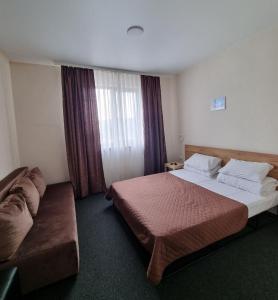 a hotel room with two beds and a couch at MAFA Hotel in Bukovel