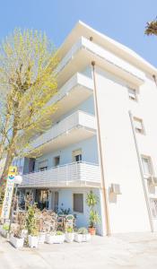 a white building with plants in front of it at Hotel Mirage in Bellaria-Igea Marina